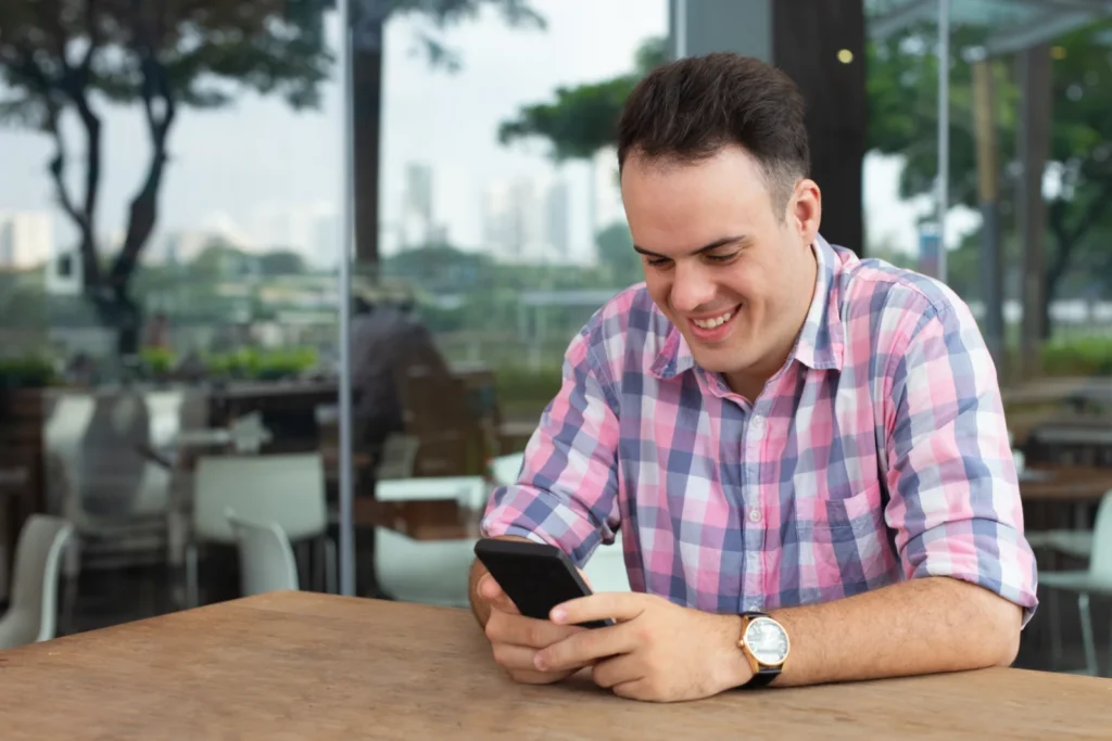Young man smiling while using an app on his smartphone